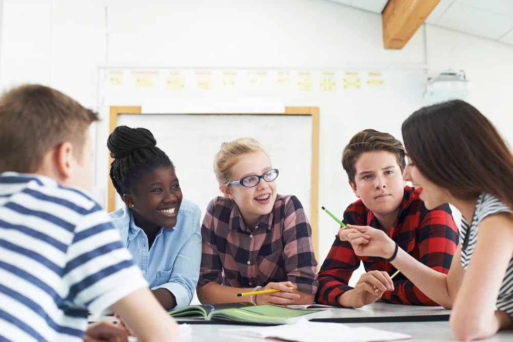 Group,Of,Teenage,Students,Collaborating,On,Project,In,Classroom